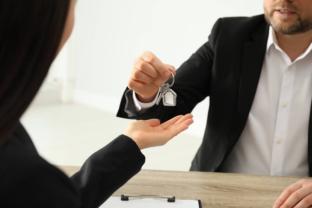 real estate agent giving key to client